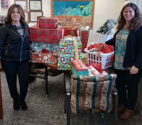 Danielle Moser, a Senior Public Health Educator with the Orange County Health Department (left), and Youth Bureau Director Rachel Wilson (right) with gifts for the County’s Adopt-a-Family program.